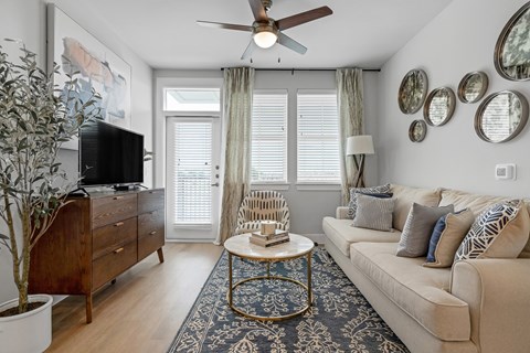 a living room with a couch and a table and a ceiling fan